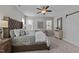 Bedroom with large bed, tufted headboard, ceiling fan, and white sliding barn door to bathroom at 8816 Knights Union Way, Wake Forest, NC 27587