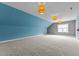 Bonus room featuring blue walls, grey accent wall and modern hanging light fixtures at 8816 Knights Union Way, Wake Forest, NC 27587