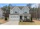 Charming two-story home featuring a covered front porch, attached garage, and well-maintained landscaping at 8816 Knights Union Way, Wake Forest, NC 27587