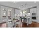 Bright kitchen with white cabinets, stainless steel appliances, island with breakfast bar, and hardwood floors at 8816 Knights Union Way, Wake Forest, NC 27587