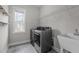 Bright laundry room with a new washer and dryer, utility sink and shelving at 8816 Knights Union Way, Wake Forest, NC 27587