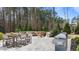 Outdoor patio featuring a fire pit, dining area, and built in grill overlooking a wooded area at 8816 Knights Union Way, Wake Forest, NC 27587