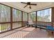 Relaxing screened porch with comfortable seating, ceiling fan, and a view of the surrounding trees at 8816 Knights Union Way, Wake Forest, NC 27587