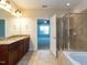 Bathroom with double sinks, tiled floor, glass shower, and soaking tub at 9221 Calabria Dr # 121, Raleigh, NC 27617