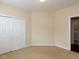 Spare bedroom with neutral carpet, closet, and doorway leading to laundry area at 9221 Calabria Dr # 121, Raleigh, NC 27617