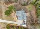 An aerial shot of the home highlighting the driveway, roof, and surrounding wooded lot at 100 Lexington Ave, Zebulon, NC 27597