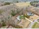 A wide aerial view displays the home's placement amidst a mix of woods and farmland at 100 Lexington Ave, Zebulon, NC 27597