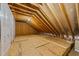 Unfinished attic space with plywood flooring and exposed roof rafters at 100 Lexington Ave, Zebulon, NC 27597