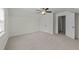 Bright bedroom featuring neutral carpet, a ceiling fan, closet and a door leading to another room at 100 Lexington Ave, Zebulon, NC 27597