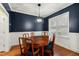 Elegant dining room with designer lighting, hardwood floors, and wainscoting at 100 Lexington Ave, Zebulon, NC 27597