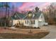Charming two-story home featuring a stone facade, an inviting front porch, and an attached garage at 100 Lexington Ave, Zebulon, NC 27597