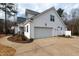 Attached garage with a paved driveway, an outdoor light, and well-maintained landscaping at 100 Lexington Ave, Zebulon, NC 27597