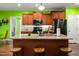 A well-lit kitchen showcases ample wooden cabinetry, stainless steel appliances, and a granite-topped island with stools at 100 Lexington Ave, Zebulon, NC 27597
