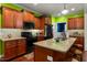 Bright kitchen featuring wooden cabinets, granite countertops, and a center island with seating at 100 Lexington Ave, Zebulon, NC 27597