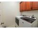 Convenient laundry room featuring a modern washer and dryer with upper cabinet storage at 100 Lexington Ave, Zebulon, NC 27597