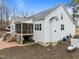 This angle shows the rear of the house with a screened porch, white siding, and brick patio at 100 Lexington Ave, Zebulon, NC 27597
