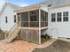 A shot of the screened porch showing its wood decking and steps to the patio at 100 Lexington Ave, Zebulon, NC 27597