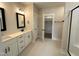 Stylish bathroom featuring double vanity, decorative tile floor, a walk-in closet, and sleek black fixtures at 100 Spumante Ct, Princeton, NC 27569