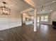 Open-concept living space with hardwood floors, wainscoting, fireplace, and a view into the spacious modern kitchen at 100 Spumante Ct, Princeton, NC 27569