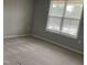 Neutral bedroom with plush carpeting and large window provides natural light at 1006 Pondfield Way, Durham, NC 27713