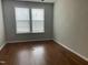 Bright bedroom with hardwood floors and natural light from a large window at 1006 Pondfield Way, Durham, NC 27713