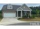 Charming single-story home featuring a stone facade, two-car garage, and well-maintained landscaping at 1006 Pondfield Way, Durham, NC 27713