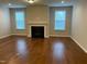 Spacious living room features a fireplace, hardwood floors, and natural light from two large windows at 1006 Pondfield Way, Durham, NC 27713