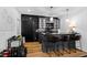 Finished basement featuring a bar with black tile backsplash, granite countertop and seating for three at 1012 Casa Dega Way, Raleigh, NC 27613
