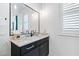 Elegant bathroom featuring a dark vanity, stone countertop, and framed mirror, with stylish fixtures at 1012 Casa Dega Way, Raleigh, NC 27613