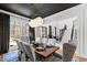 Stylish dining room with modern lighting, dark ceiling, white wainscoting and view into the foyer at 1012 Casa Dega Way, Raleigh, NC 27613
