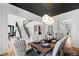 Chic dining room with high ceilings, view of staircase, dark ceiling, and modern lighting fixture at 1012 Casa Dega Way, Raleigh, NC 27613
