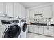 Laundry room featuring white cabinetry and black and white patterned tile backsplash at 1012 Casa Dega Way, Raleigh, NC 27613