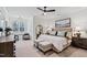 A cozy bedroom features a large window, a stylish ceiling fan, an oversized mirror and comfortable furnishings at 1012 Casa Dega Way, Raleigh, NC 27613