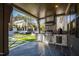 Outdoor kitchen with stainless steel appliances, stone surround, and views of the backyard at 1012 Casa Dega Way, Raleigh, NC 27613