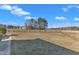 View of backyard with a grass lawn, fence, and cluster of trees at 103 Fieldstone Dr, Clayton, NC 27520
