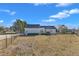 View of the white house showcasing the expansive backyard and tidy landscaping beneath a bright blue sky at 103 Fieldstone Dr, Clayton, NC 27520