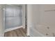Bathroom featuring a glass door shower, a soaking tub, and wood-look flooring at 103 Fieldstone Dr, Clayton, NC 27520