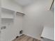 Bright laundry room with wooden-style flooring and a convenient shelving rack at 103 Fieldstone Dr, Clayton, NC 27520
