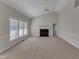 Open living room featuring neutral walls and carpet, a cozy fireplace, and large windows for ample light at 103 Fieldstone Dr, Clayton, NC 27520