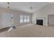 Spacious living room with neutral carpet, fireplace, ceiling fan, and large windows for ample natural light at 103 Fieldstone Dr, Clayton, NC 27520
