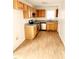 Functional kitchen featuring wooden cabinetry, stainless steel appliances, and laminate flooring at 105 Cross Hill Ln, Holly Springs, NC 27540