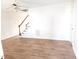 Bright living room featuring wood-look flooring, stairs, a ceiling fan, and neutral paint at 105 Cross Hill Ln, Holly Springs, NC 27540