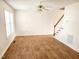 Sunlit living room showcasing wood-look floors, stairs, ceiling fan and natural light from large window at 105 Cross Hill Ln, Holly Springs, NC 27540