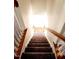 Carpeted staircase with white risers and stained wood handrail at 105 Cross Hill Ln, Holly Springs, NC 27540