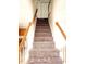 Carpeted stairs with wooden and white railing lead to the upper level of the home at 105 Cross Hill Ln, Holly Springs, NC 27540