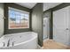Bathroom featuring a large tub beneath a window and glass shower with tile flooring at 106 Jared Ct, Graham, NC 27253