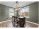 Bright dining area with a modern light fixture, large windows, and views of the backyard at 106 Jared Ct, Graham, NC 27253