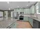 Modern kitchen featuring stainless steel appliances, ample cabinet space, and a view of the living area at 106 Jared Ct, Graham, NC 27253