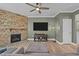 Cozy living room with a stone fireplace, ceiling fan, and a large television for entertainment at 106 Jared Ct, Graham, NC 27253