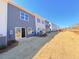 Exterior view of newly constructed townhomes showcasing grass and back patios at 112 Central Townes Way # 294, Raleigh, NC 27603